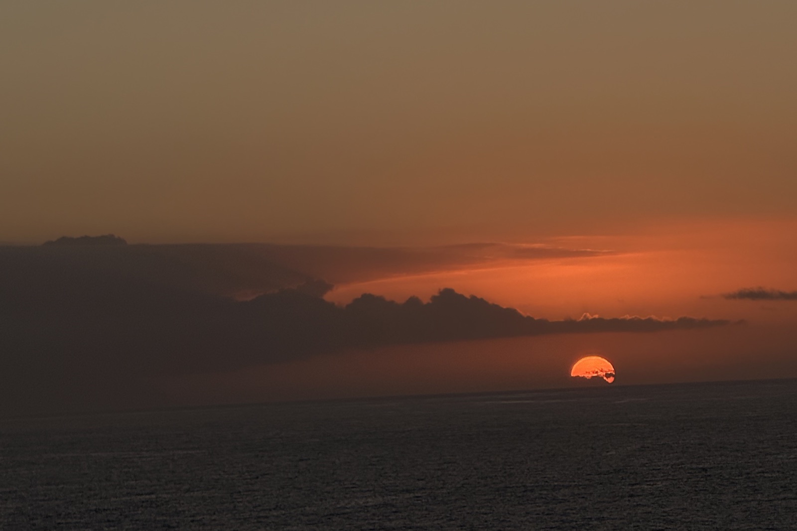 Orange sunset over the sea with a band of cloud
