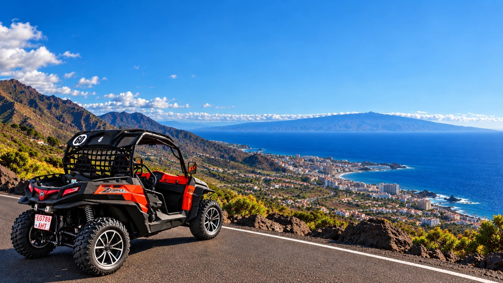 An orange buggy parked on the road, with the Adeje coast below, the blue sea and La Gomera in the distance